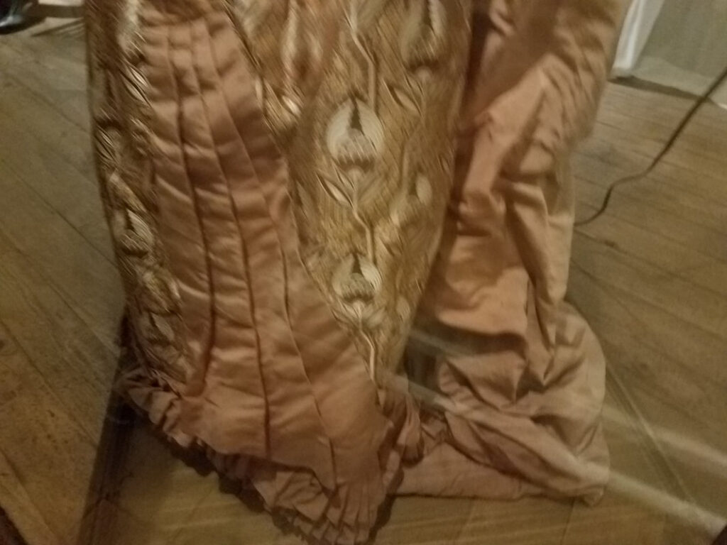 Victorian bustle-era skirt draping and patterned underskirt