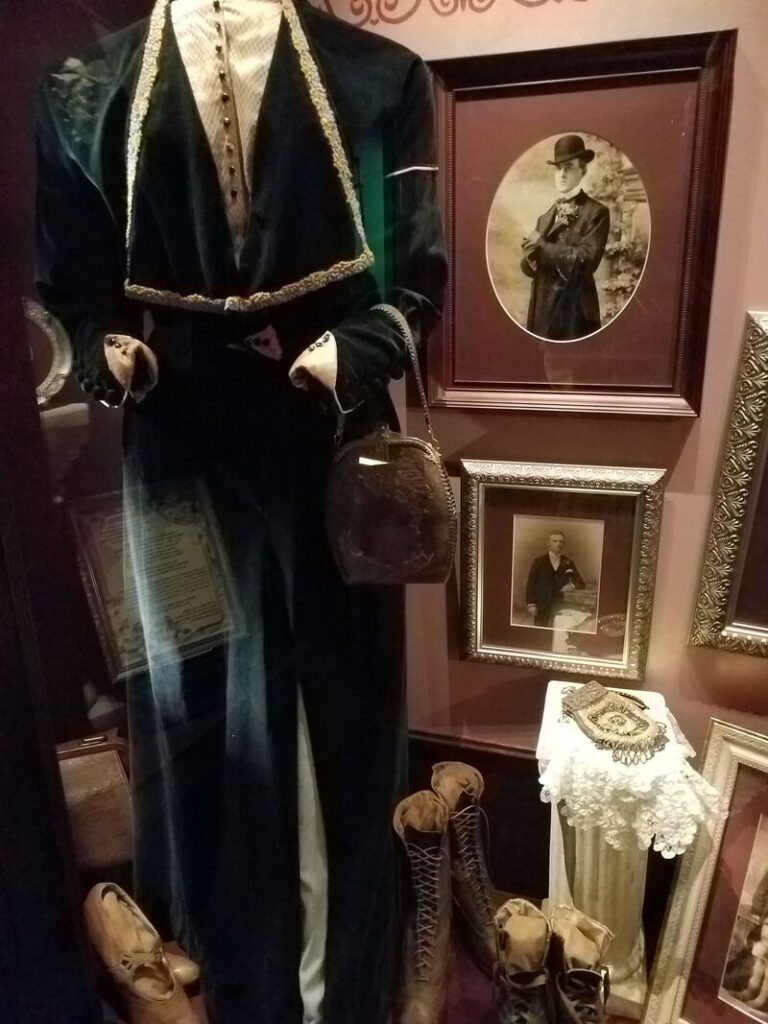 Historic dark Victorian women's tailored suit with boots and handbag at Boot Hill Museum