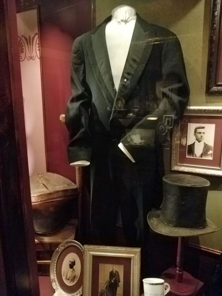 Historic men's black formal tailcoat and top hat displayed at Boot Hill Museum