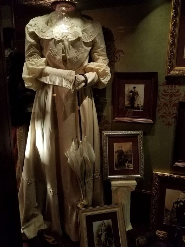 Historic light colored Victorian or Edwardian dress with decorative collar and parasol at Boot Hill Museum
