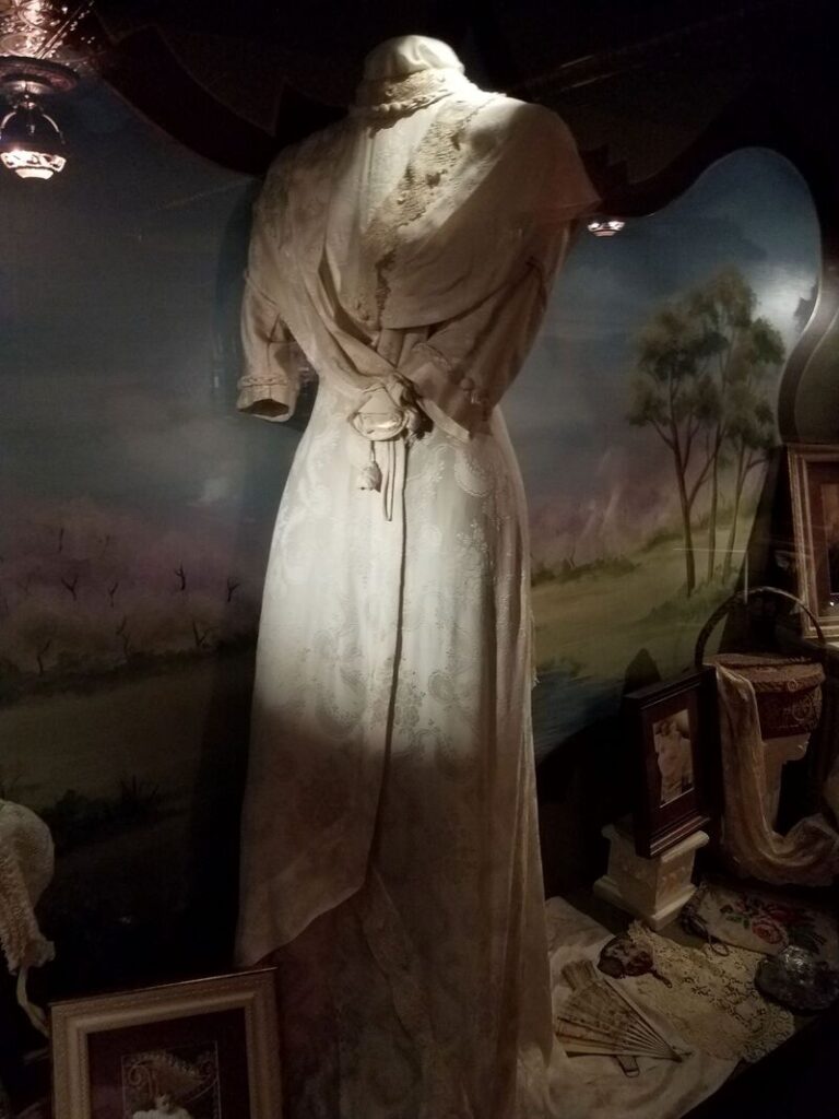 Historic light-colored dress with asymmetrical draped bodice and skirt displayed at Boot Hill Museum in Dodge City